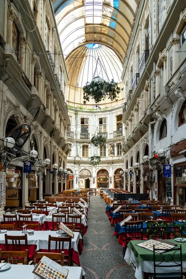 The glass-roofed passage in Pera, tables laid under the dome